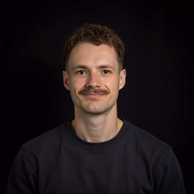 Studio portrait of the site owner against a black background.